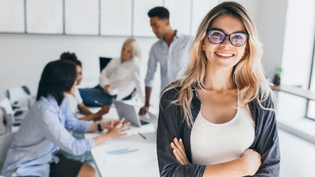 blonde-female-executive-posing-with-smile-arms-crossed-during-brainstorm-with-managers-indoor-portrait-european-student-spending-time-hall-with-asian-african-friends