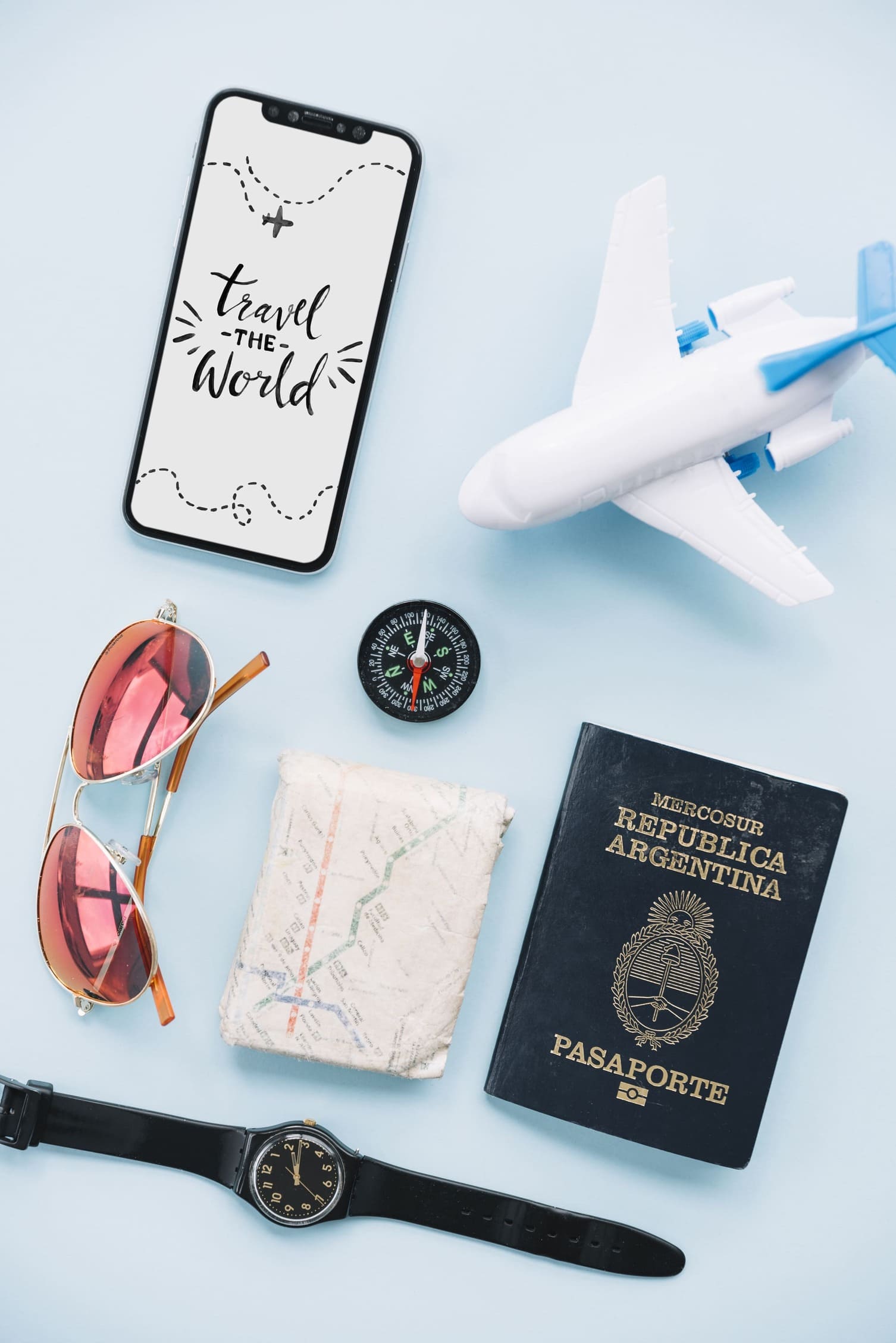travel-world-message-smartphone-with-sunglasses-wrist-watch-map-passport-compass-toy-airplane